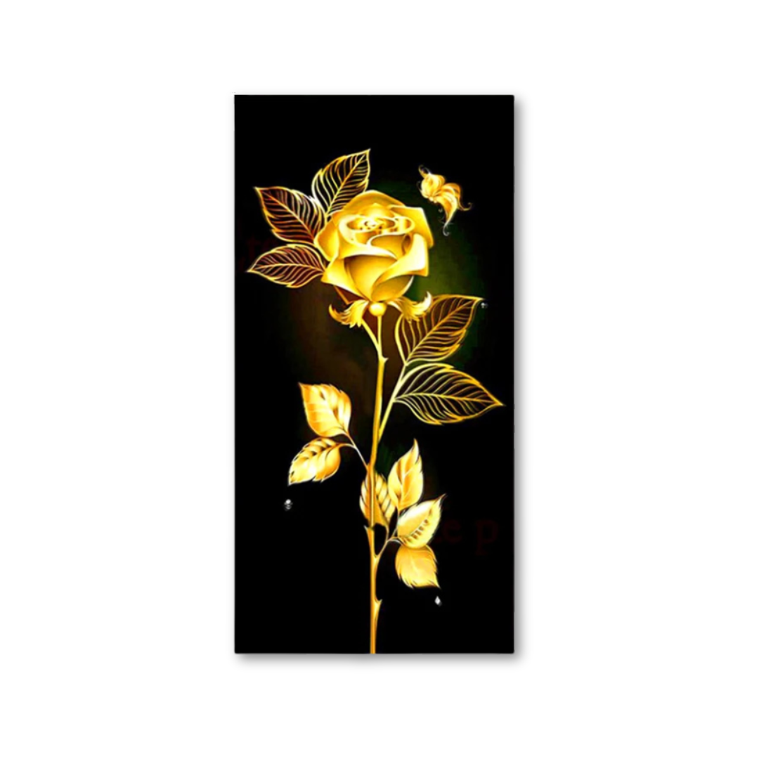 A vertical rectangular art print featuring a glowing golden rose with leaves on a black background, shown against a white studio backdrop.