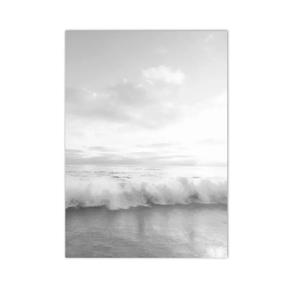 A vertical black and white photographic print of a wave breaking on a beach under a cloudy sky, shown as a rectangular canvas or poster centered on a white background.