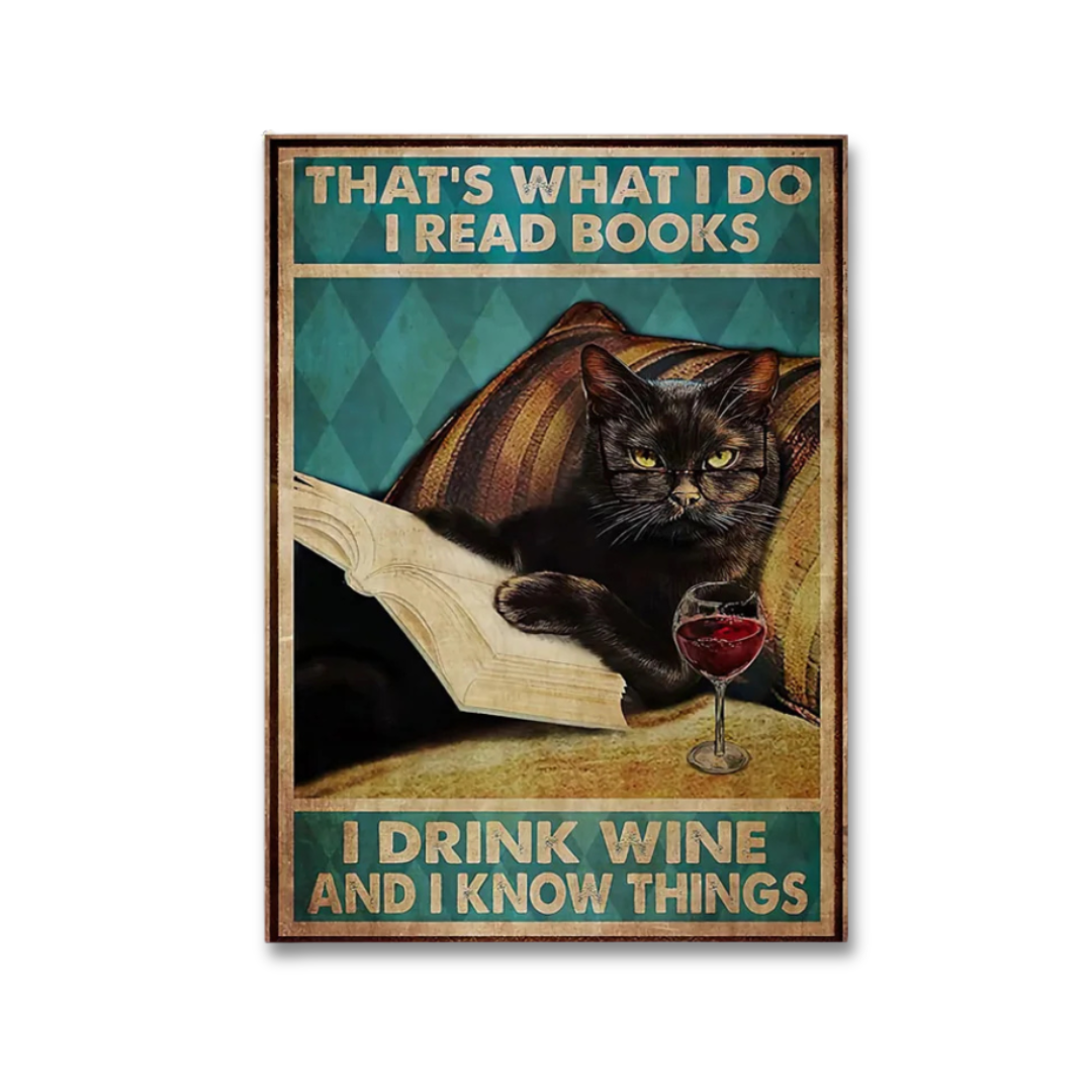 A vintage-style humorous poster featuring a black cat reading a book and holding a glass of red wine, with the text 'THAT'S WHAT I DO I READ BOOKS' at the top and 'I DRINK WINE AND I KNOW THINGS' at the bottom.