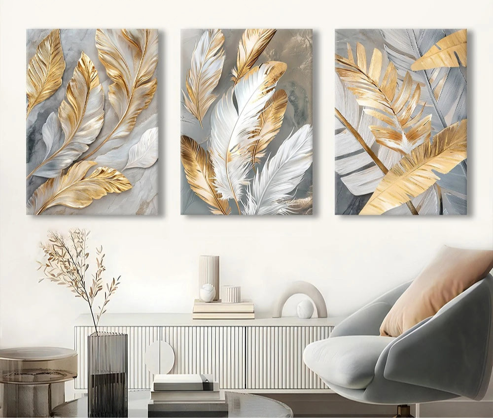 Three abstract wall art panels with gold and silver leaves in a living room setting.