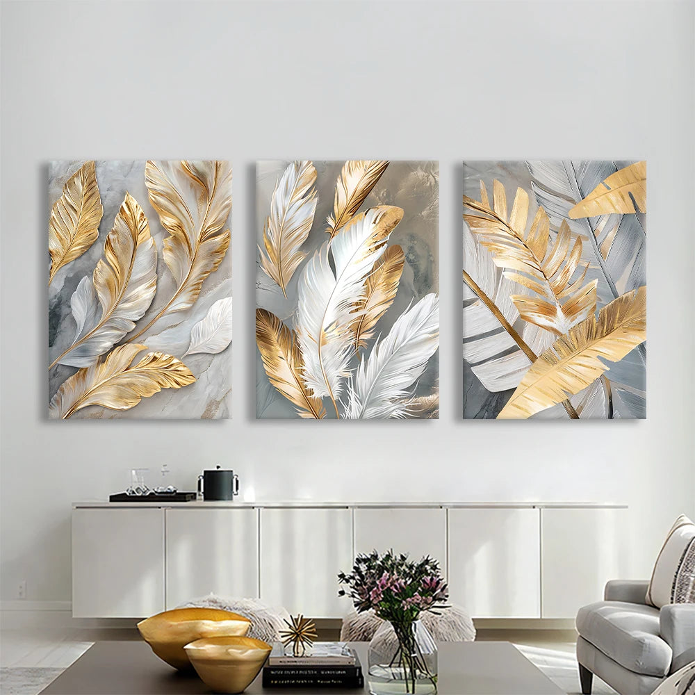 Three abstract wall art pieces with gold and silver leaves on a white wall.