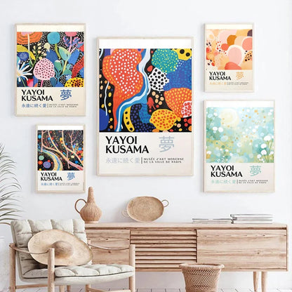 Colorful Yayoi Kusama posters on a wall above a wooden console table.