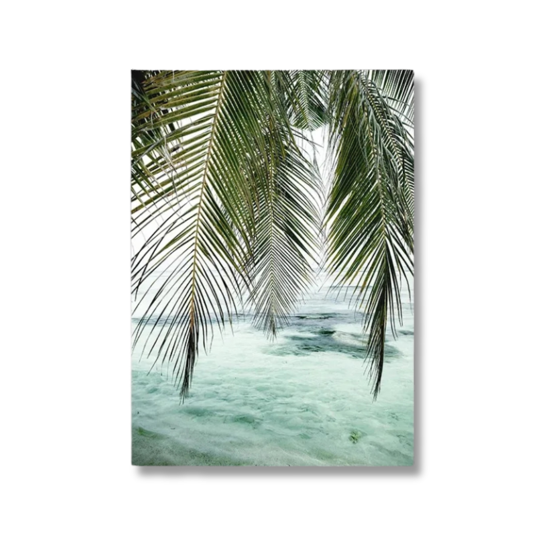 A vertical canvas wall art print depicting green palm fronds hanging over pale turquoise ocean water, shown against a plain white background.