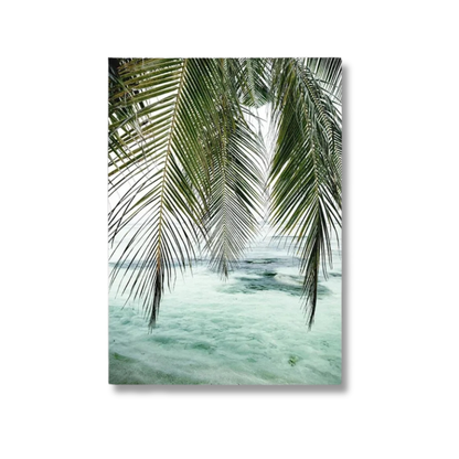 A vertical canvas wall art print depicting green palm fronds hanging over pale turquoise ocean water, shown against a plain white background.